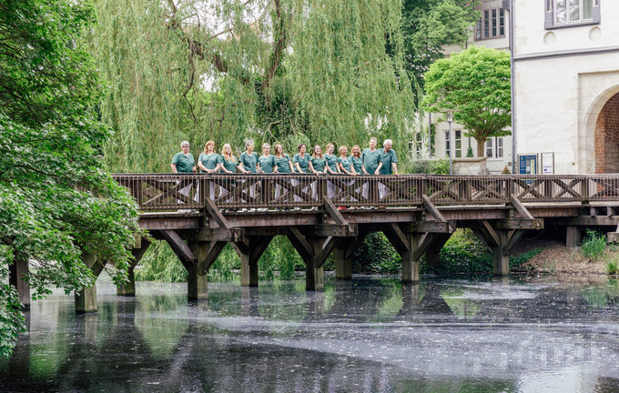 Dies ist das Team des MVZ Herz Gifhorn auf einer Brücke vor dem Schloss.