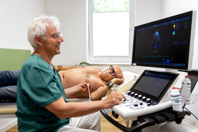 Ein Arzt macht einen Herzultrallschall bei einem Patienten.